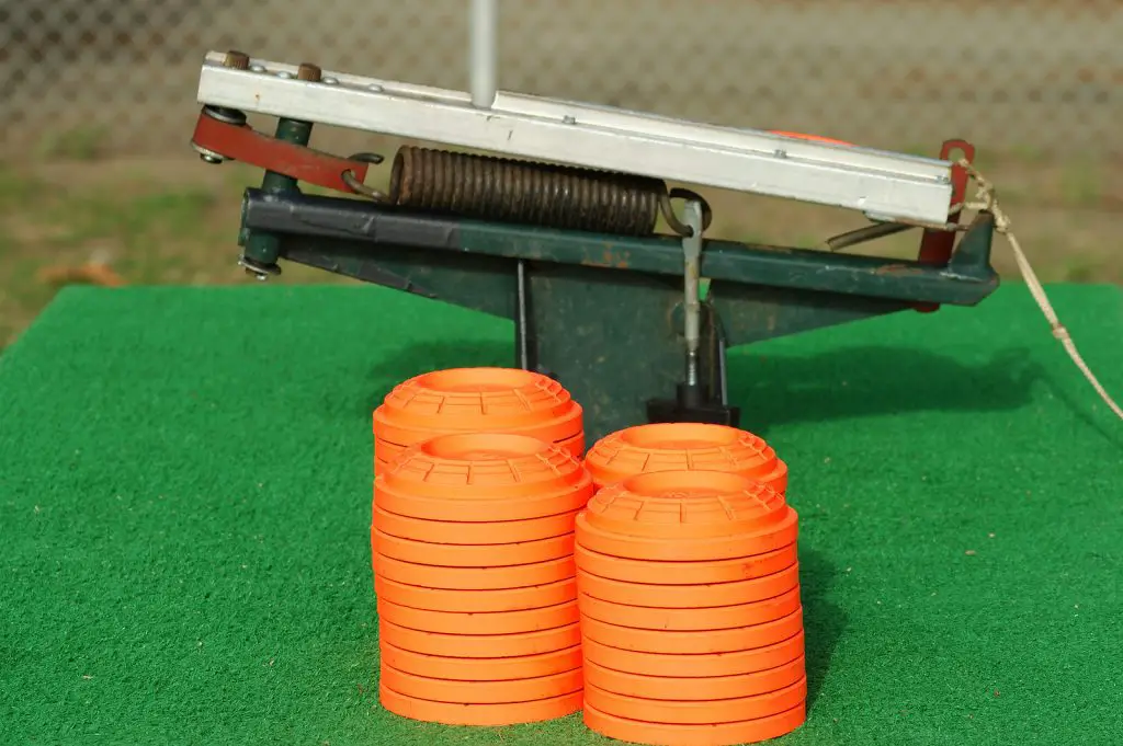 Clay pigeons stacked next to a portable trap thrower mounted on - The