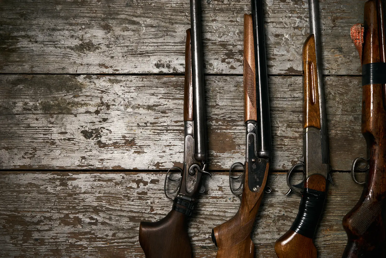 three shotguns on a wooden background