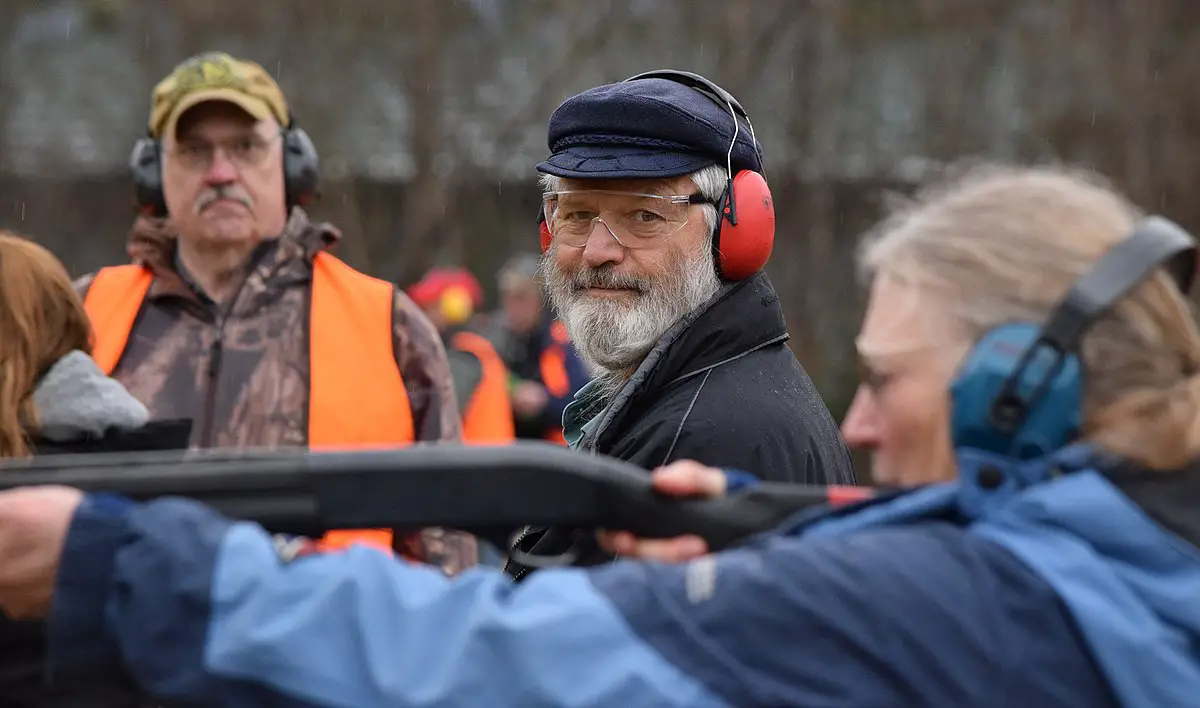 Rep. Paul Seaton (R-Homer) watches as Poppy Benson takes a shot during the trap shooting portion of the 19th annual Legislative Shoot on Saturday, March 21, 2015. Teams of legislators, aides and members of the media form three-person teams in a four-event shooting contest that covers shotgun, rifle, pistol and archery accuracy. Trap shooting for beginners