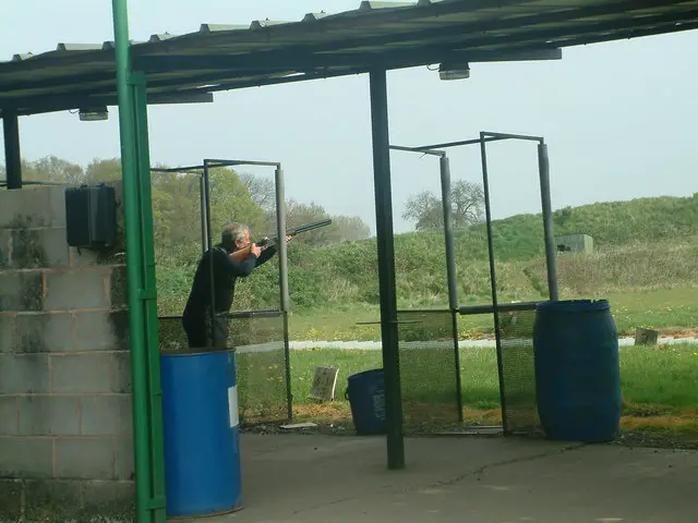 a man with a shotgunn clay pigeon shooting